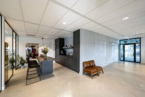 Moderne kantoorruimte in Rietlandpark met koffiehoek, hoge zitplaatsen en een minimalistisch interieur.