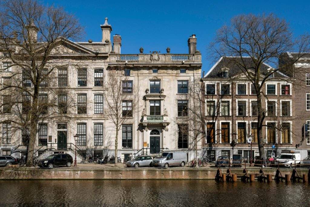 Gevels van monumentale grachtenpanden aan de Herengracht in Amsterdam, gezien vanaf de overkant van het water.