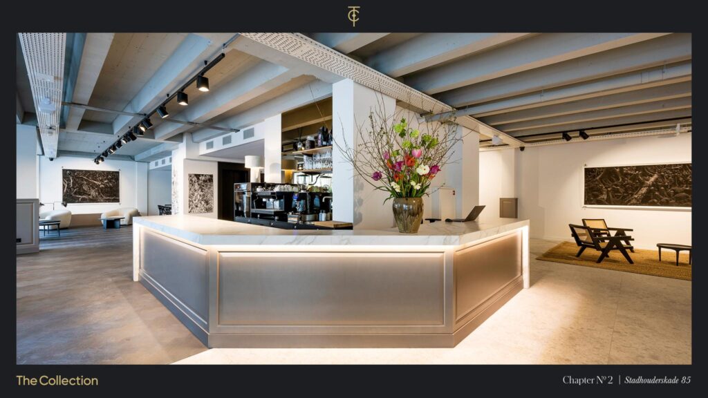 Modern interior of a stylish showroom at Stadhouderskade 85 with a marble reception desk, flower arrangement, and contemporary art on the walls.