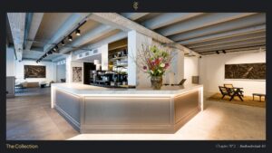 Modern interior of a stylish showroom at Stadhouderskade 85 with a marble reception desk, flower arrangement, and contemporary art on the walls.