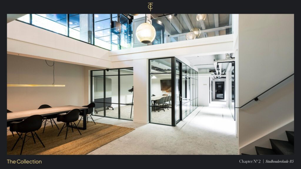Modern office interior at Stadhouderskade 85 featuring glass meeting rooms, a long wooden table, and contemporary lighting.