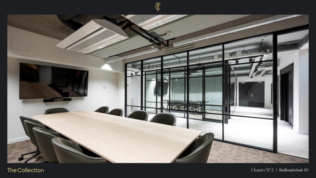 Modern conference room at Stadhouderskade 85 with glass walls, a large wooden table, and a wall-mounted screen.