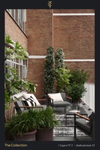 Modern outdoor seating area on a terrace at Stadhouderskade 85, surrounded by lush potted plants and brick walls.