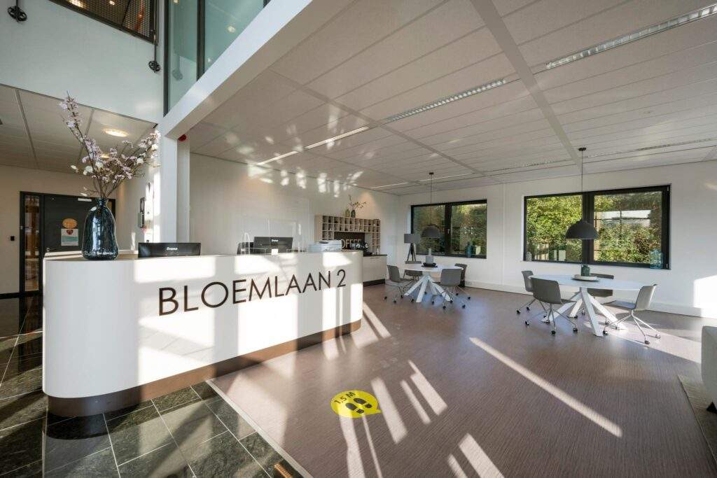 Moderne en lichte ontvangsthal met balie en zitgedeelte aan de Bloemlaan 2.