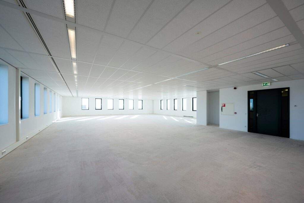 Lichte, lege kantoorruimte aan de Bloemlaan met grote ramen en systeemplafond.