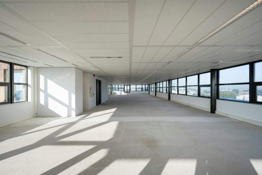 Licht en ruim leeg kantoorpand aan de Bloemlaan met grote ramen en een systeemplafond.
