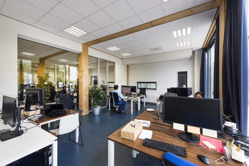 Moderne open kantoorruimte aan de Nieuwendammerkade met bureaus, computers en werkende medewerkers.