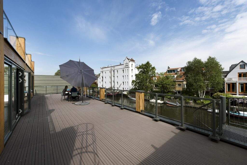 Zonnig dakterras aan de Nieuwendammerkade met uitzicht op een gracht en historische panden.