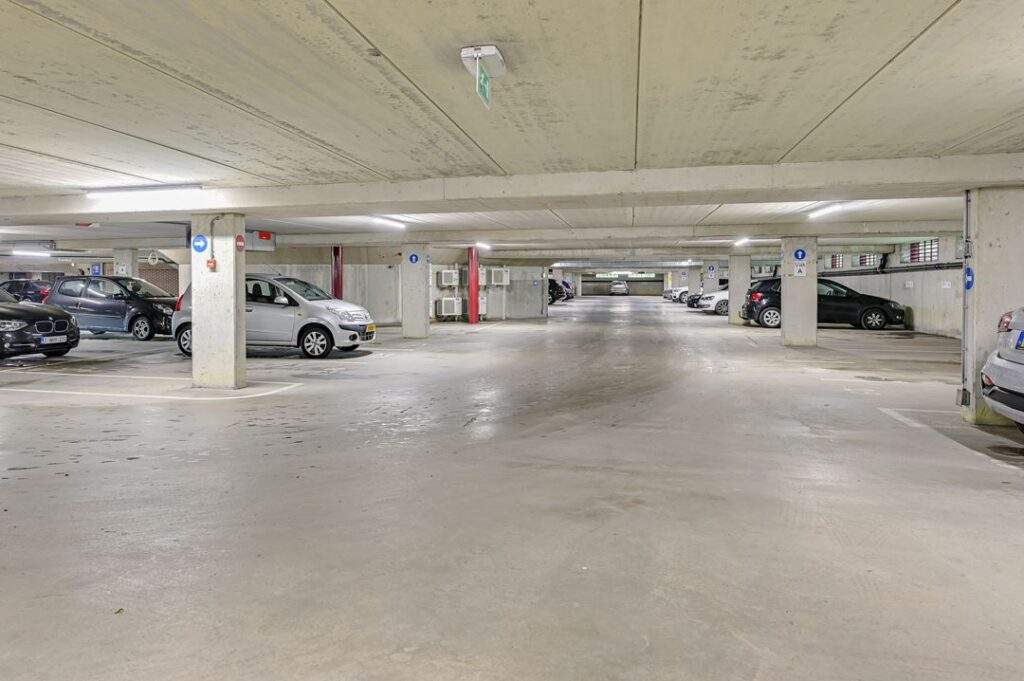 Ondergrondse parkeergarage aan de Kingsfordweg met geparkeerde auto's en betonnen pilaren.