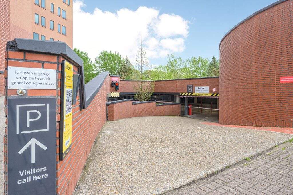 Ingang van een parkeergarage aan de Kingsfordweg met bord voor bezoekers en waarschuwingsborden.