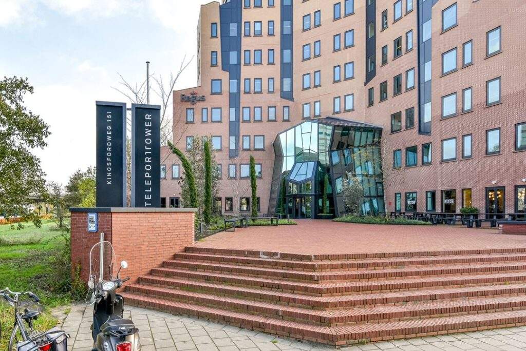 Ingang van het kantoorgebouw Teleport Tower aan de Kingsfordweg 151 in Amsterdam, met bord en trappen op de voorgrond.