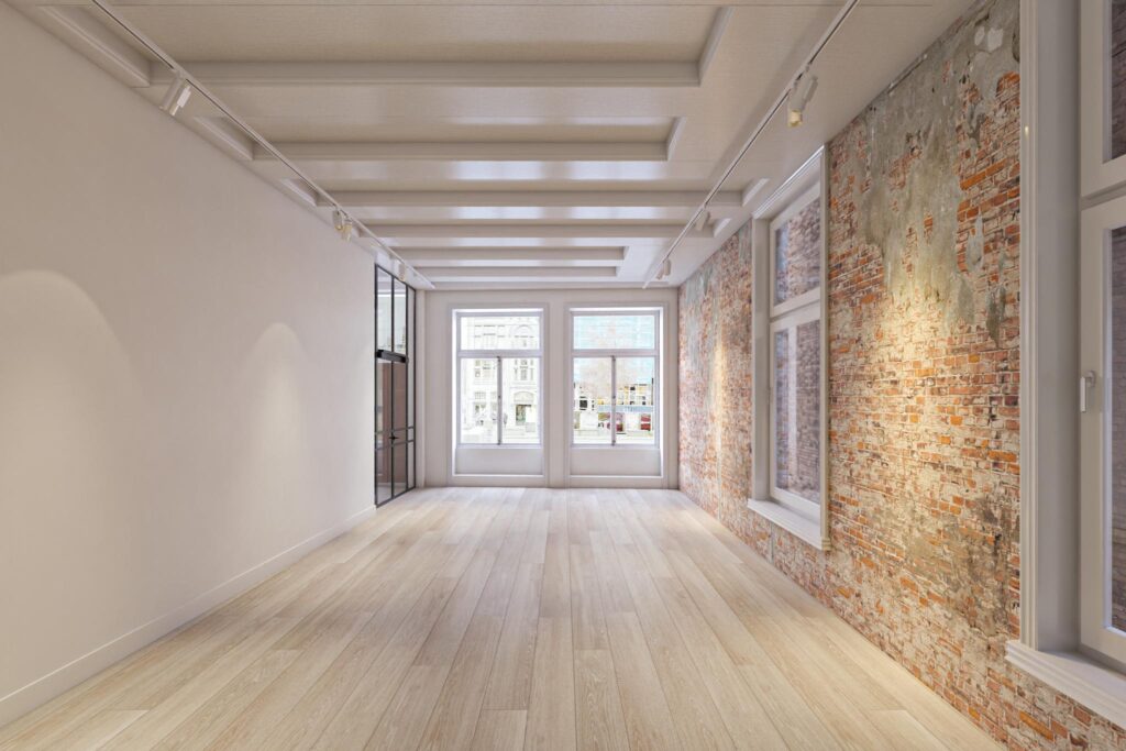 Licht en modern interieur met houten vloer, bakstenen muur en grote ramen aan het Rokin.