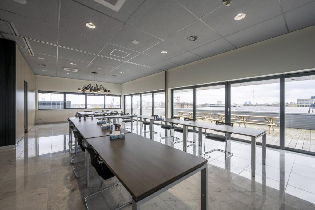Vergaderruimte met moderne inrichting en uitzicht op het dakterras aan de Dynamostraat.