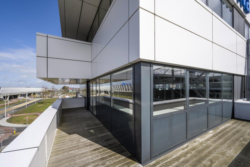 Moderne kantoorruimte aan de Dynamostraat met glazen gevel en balkon met houten vloer.