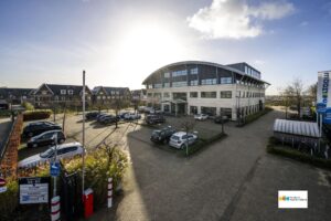 Kantoorpand aan de Singaporestraat in een bedrijventerrein met parkeerplaatsen en woonhuizen op de achtergrond.