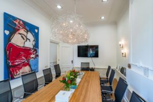 Vergaderruimte aan de Herengracht met moderne inrichting, opvallend kunstwerk en sierlijke lichtinstallatie.