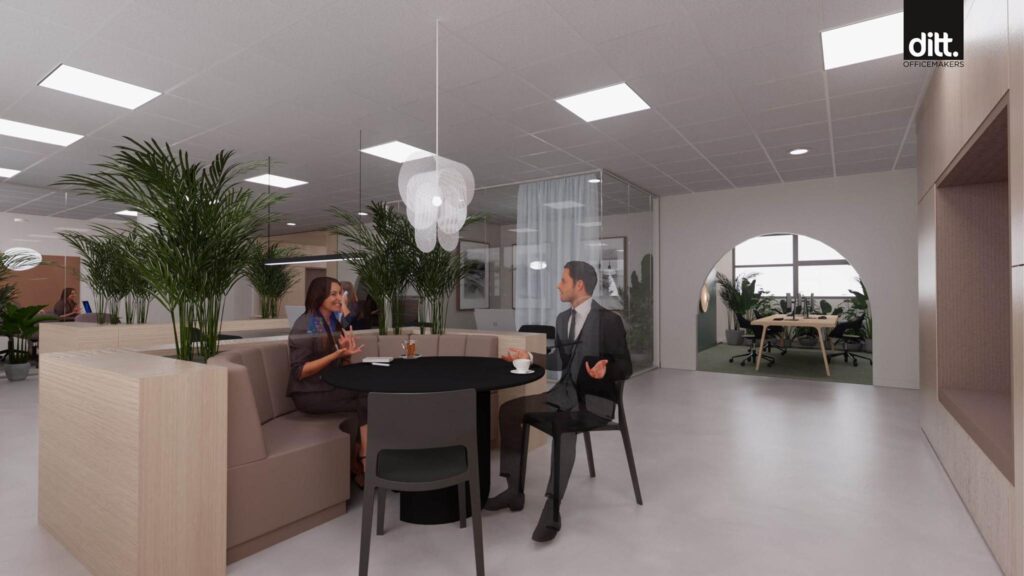 Moderne kantoorruimte aan de Spicalaan met mensen in gesprek aan een ronde tafel in een open, groen ingerichte werkomgeving.