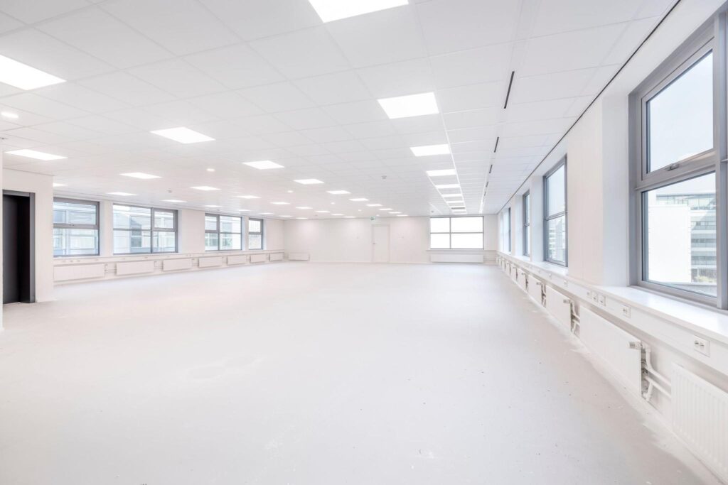 Licht en ruim leeg kantoorpand aan de Spicalaan met grote ramen en systeemplafond.