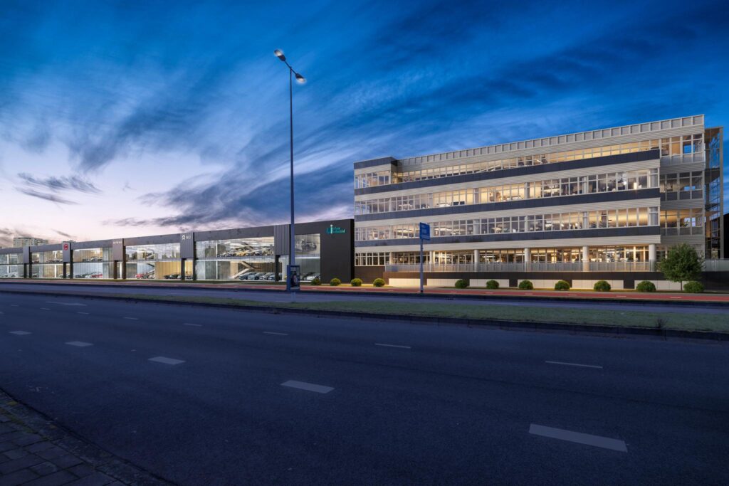 Modern kantoorpand en autoshowroom aan de Lemelerbergweg in Amsterdam tijdens schemering.