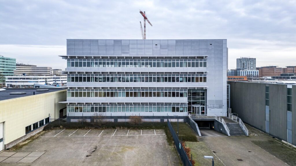 Kantoorpand aan de Lemelerbergweg met moderne gevel en parkeergelegenheid op de voorgrond.
