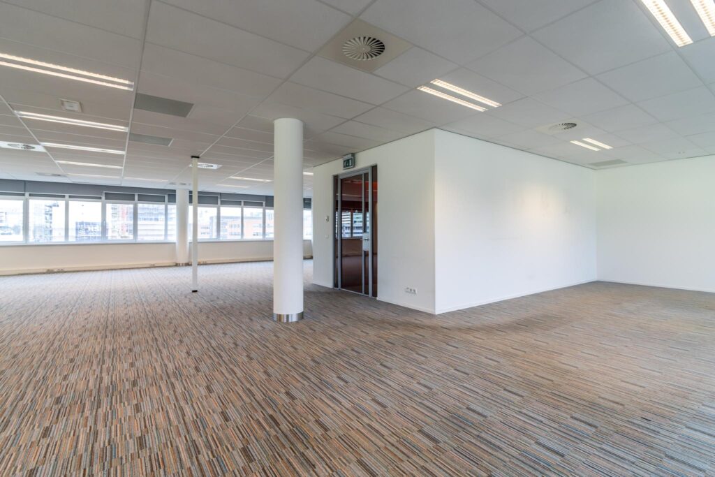 Licht en modern kantoorpand aan de Lemelerbergweg met grote ramen, systeemplafond en tapijtvloer.