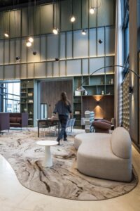 Moderne lounge- en vergaderruimte in Amstelplein met designmeubilair en hoge plafonds.