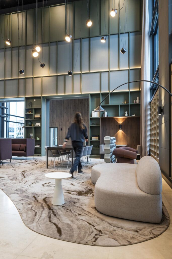 Moderne lounge- en vergaderruimte in Amstelplein met designmeubilair en hoge plafonds.