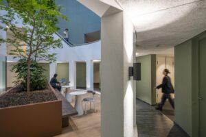 Moderne kantoorruimte in Amstelplein met een binnentuin, zitplekken en passerende personen.