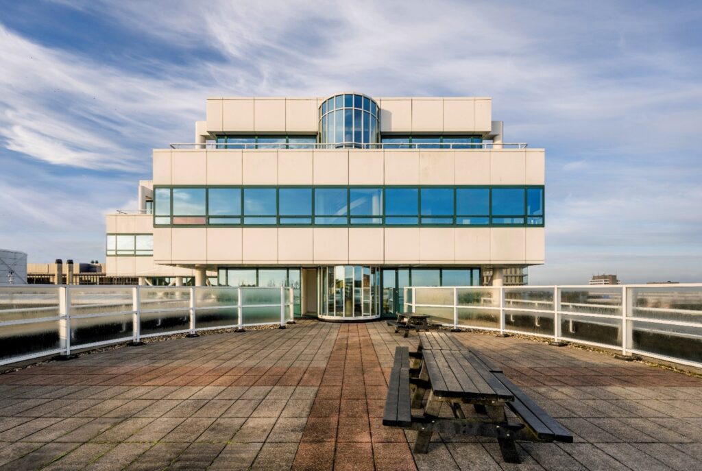 Vooraanzicht van het kantoorgebouw aan de Paalbergweg met dakterras en picknicktafels.