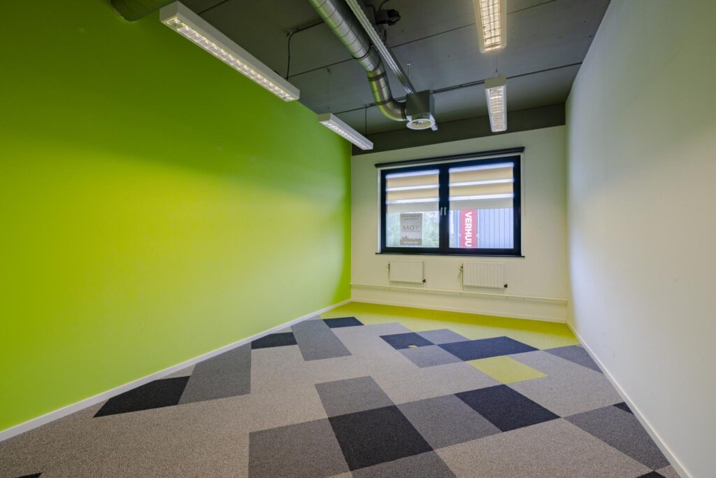 Leeg kantoorruimte aan de Laarderhoogtweg met groene muur en modern patroon op de vloerbedekking.