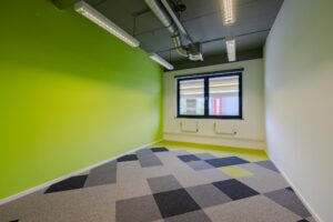 Leeg kantoorruimte aan de Laarderhoogtweg met groene muur en modern patroon op de vloerbedekking.