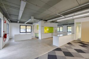 Moderne kantoorruimte aan de Laarderhoogtweg met open keuken en groene wandtegels.