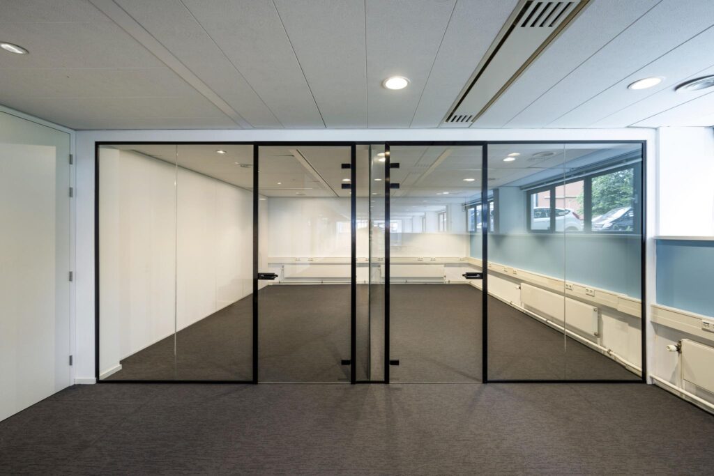Moderne, lege kantoorruimte met glazen wand en zwarte deurkozijnen in het gebouw aan de Stroombaan.