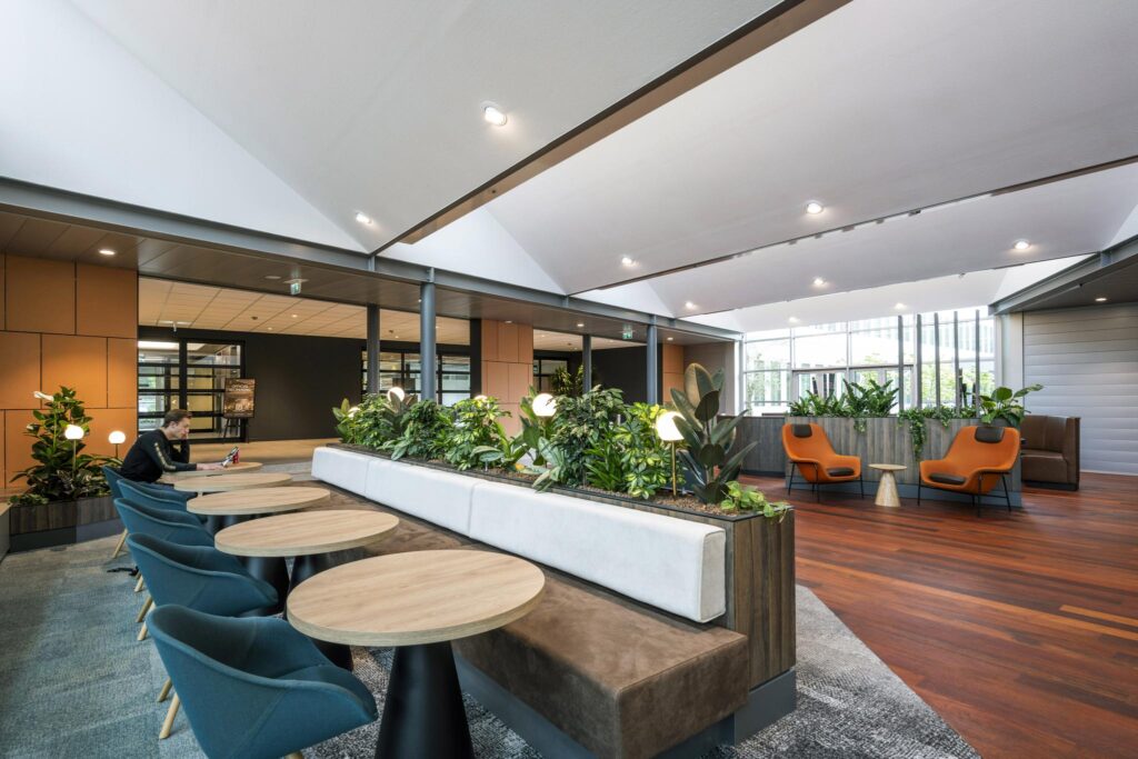 Modern lounge area at Jachthavenweg with seating, greenery, and natural light.
