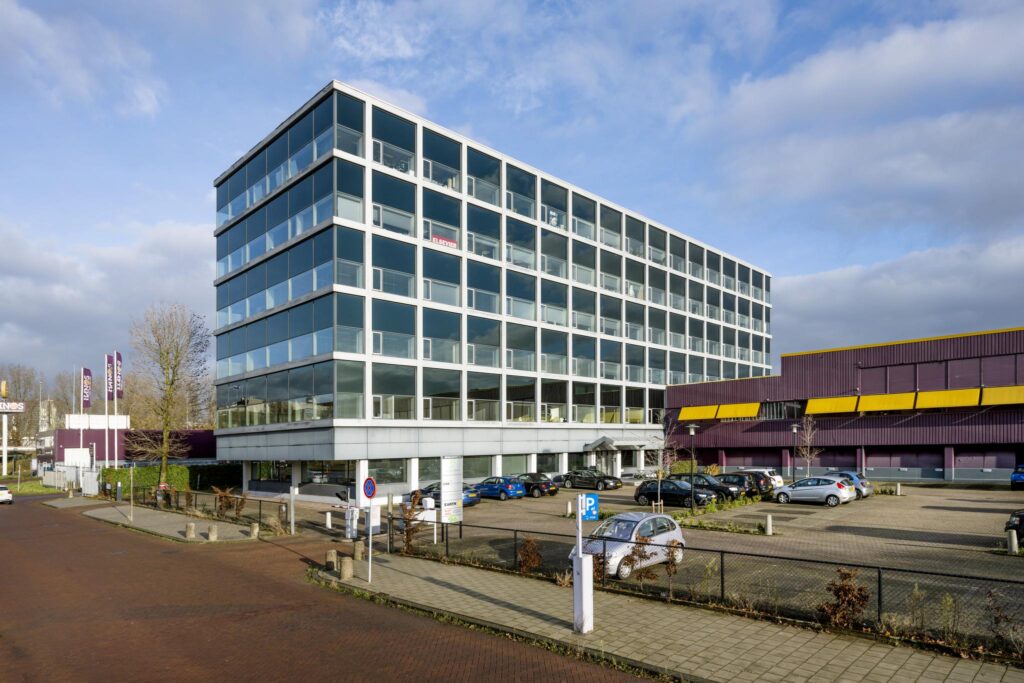 Kantoorgebouw aan de Spaklerweg in Amsterdam met parkeerterrein op de voorgrond.