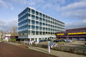 Kantoorgebouw aan de Spaklerweg in Amsterdam met parkeerterrein op de voorgrond.