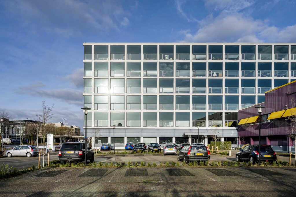 Modern kantoorgebouw aan de Spaklerweg met parkeerplaatsen op de voorgrond.