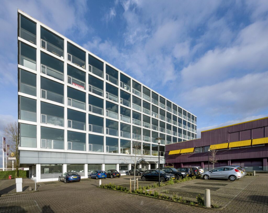 Modern kantoorgebouw aan de Spaklerweg met grote glazen gevel en parkeergelegenheid op de voorgrond.