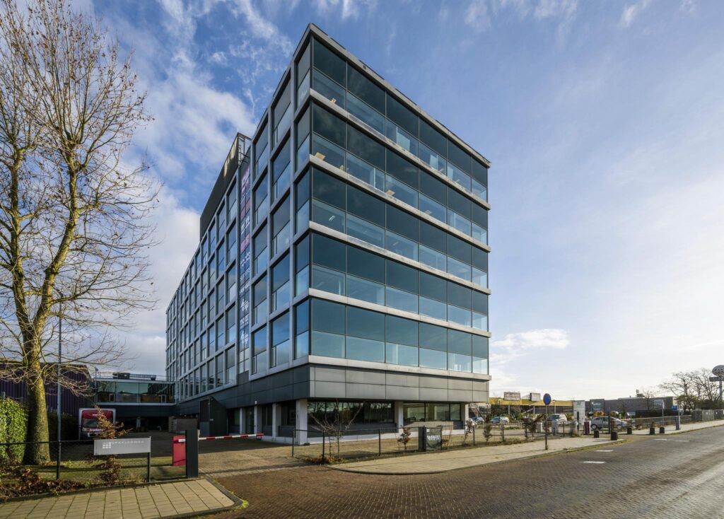 Modern kantoorgebouw aan de Spaklerweg met glazen gevel en zes verdiepingen.
