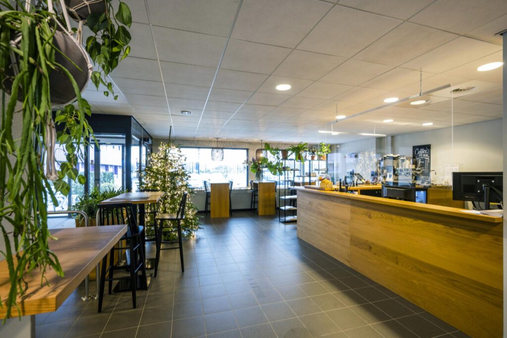 Moderne koffiebar aan de Spaklerweg met houten balie, kerstboom en veel groen.