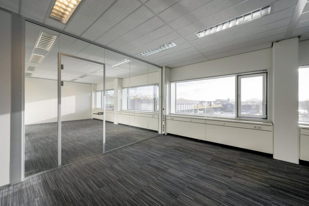 Licht en modern kantoorpand aan de Spaklerweg met glazen scheidingswand en uitzicht op de stad.