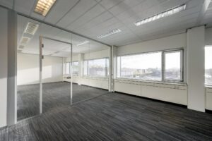 Licht en modern kantoorpand aan de Spaklerweg met glazen scheidingswand en uitzicht op de stad.