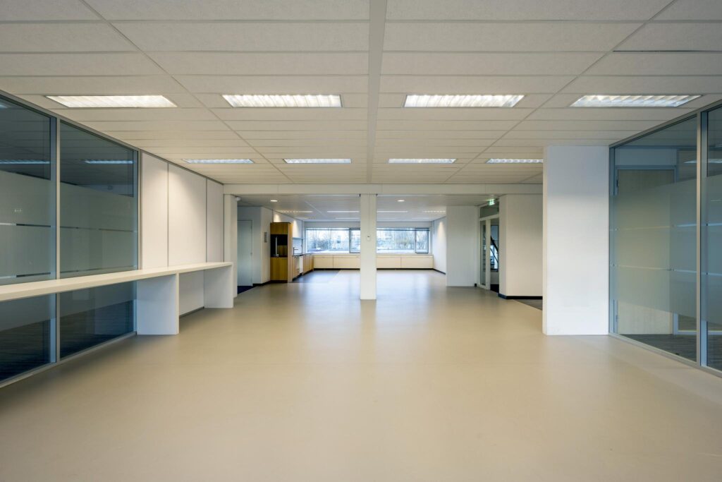 Licht en modern kantoorpand aan de Spaklerweg met grote ramen en glazen scheidingswanden.