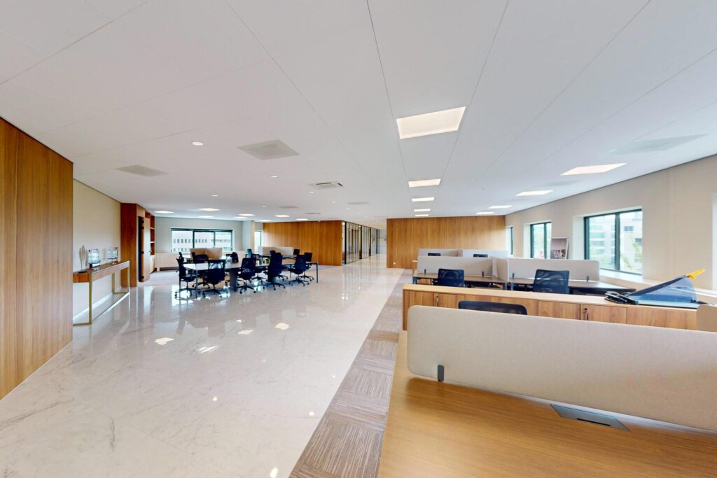 Modern open-plan office space at Wegalaan with shared desks, meeting areas, and large windows providing natural light.