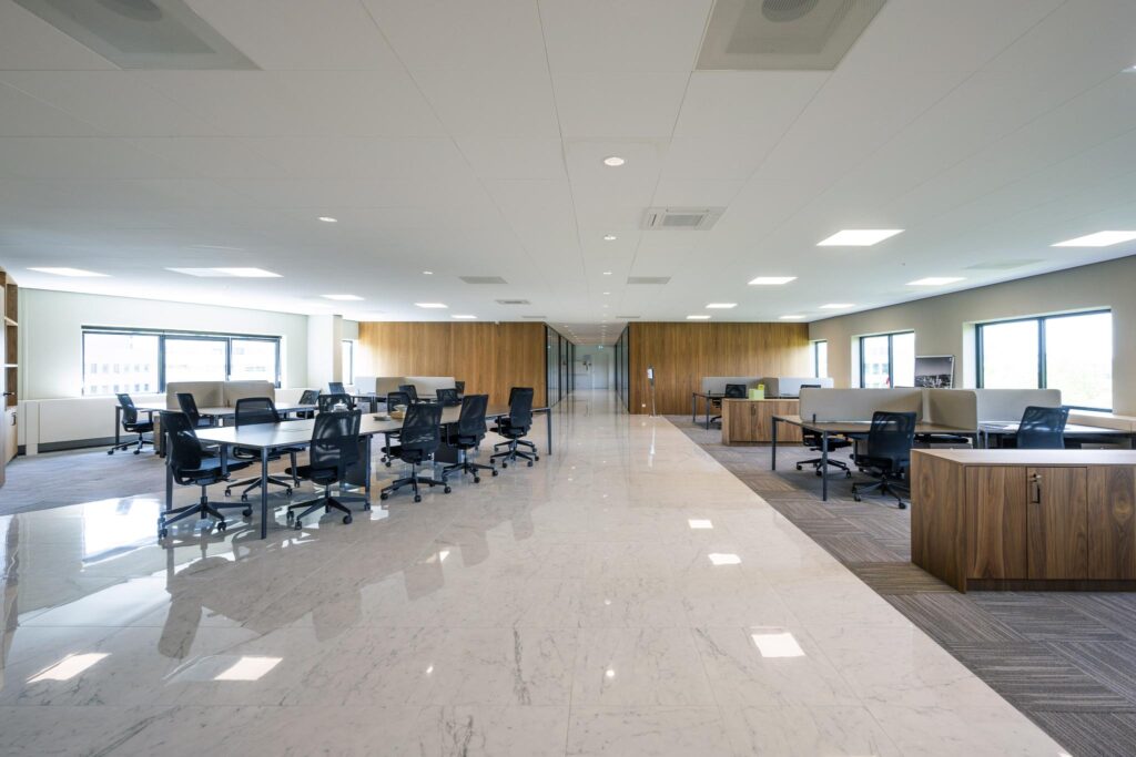 Modern open-plan office space with marble flooring and wooden accents at Wegalaan.