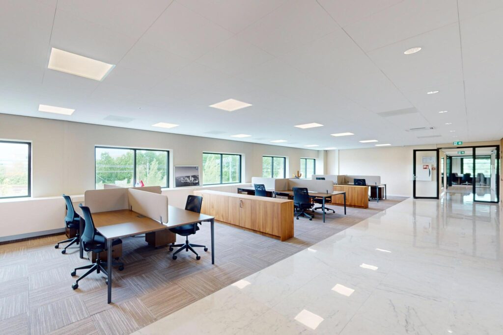 Modern open-plan office space with multiple workstations, large windows, and bright lighting at Wegalaan 188.