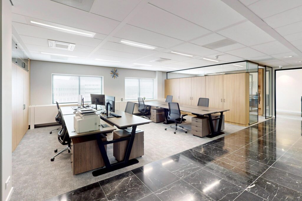 Modern open-plan office at Wegalaan with ergonomic desks, black chairs, and large windows.