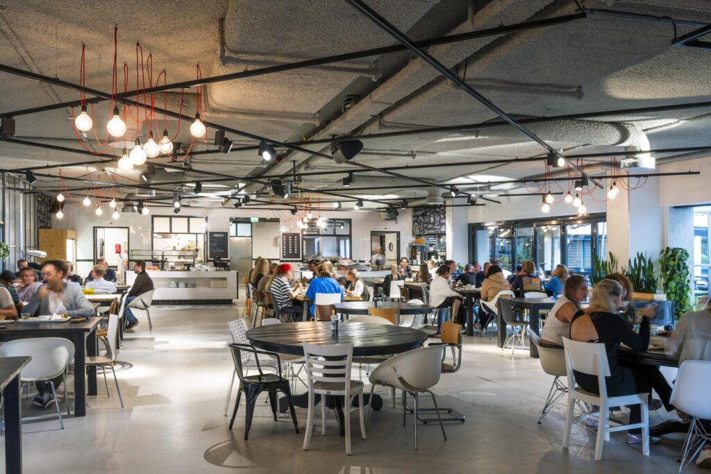Modern cafeteria at Diemermeer filled with people dining and socializing.