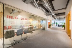 Moderne kantoorruimte met glazen vergaderruimte genaamd "Oud Zuid" en open werkplekken in de Helmholtzstraat.