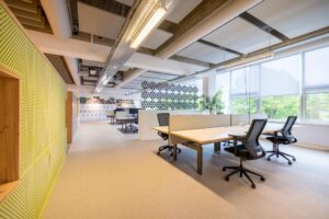 Modern en licht kantoorinterieur aan de Helmholtzstraat met werkplekken, designscheidingswand en grote ramen.